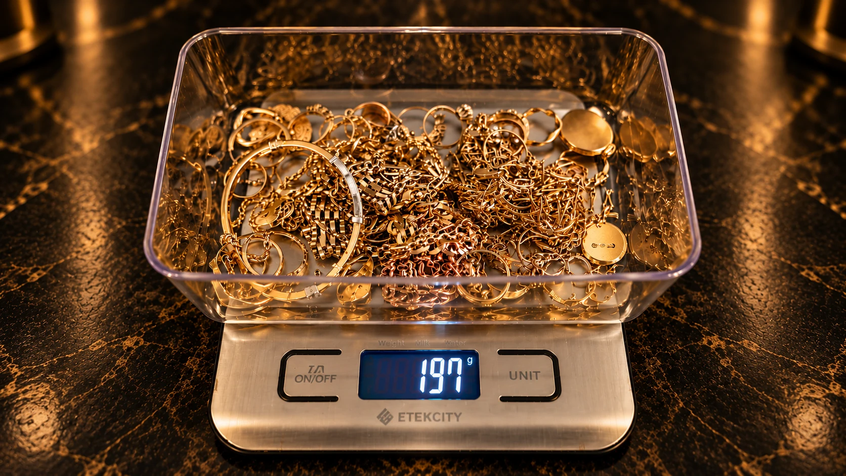 Gold jewellery in a clear container on a digital scale reading 197 g